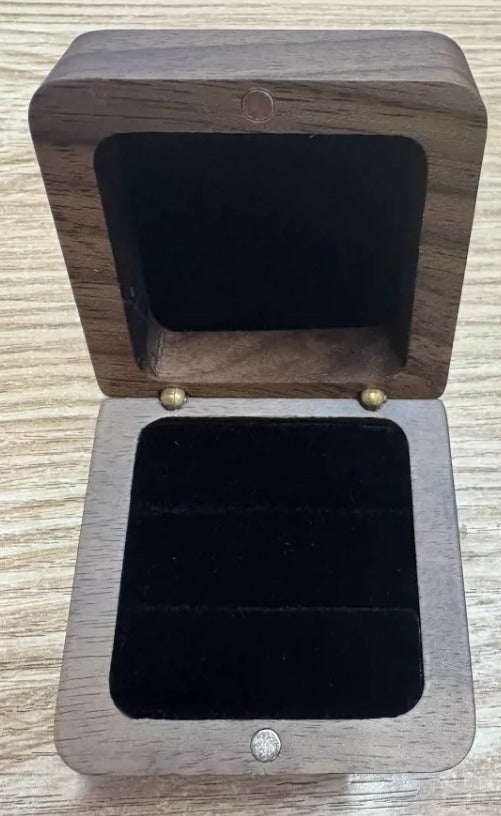 Geöffnete Ringbox aus dunklem Holz, innen schwarzer Samt mit zwei Ringschlitzen, kein Ring enthalten
